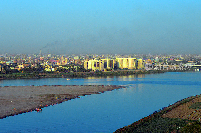 喀土穆北部/喀土穆Bahri横跨蓝色尼罗河-图提岛和尼罗河街的田地在前景，喀土穆，苏丹